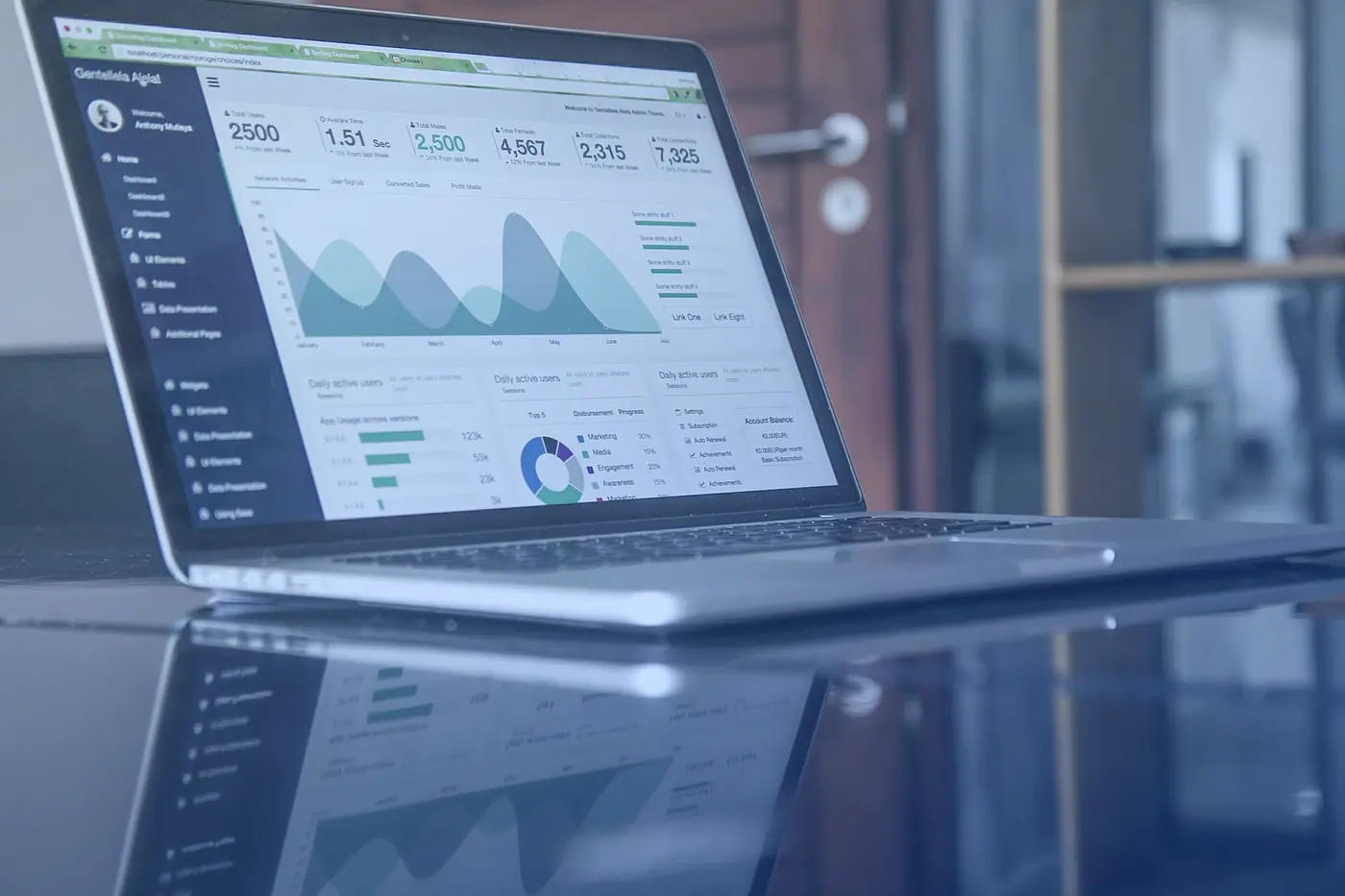 A laptop showing a dashboard of statistics