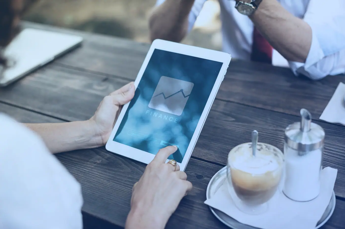 A tablet showing financial analytics beside a coffee